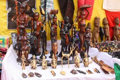 Statuettes de bois sculpte et bronzes exposes sur une table