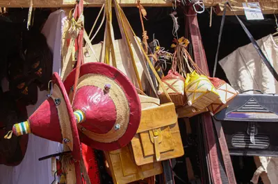 Chapeaux de paille et sacoches de cuir suspendus a un etal