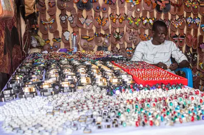 Exposant derriere son etal de bijoux et de perles