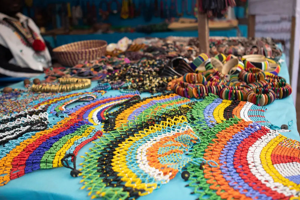 Bracelets et colliers de perles colorees disposes sur une table
